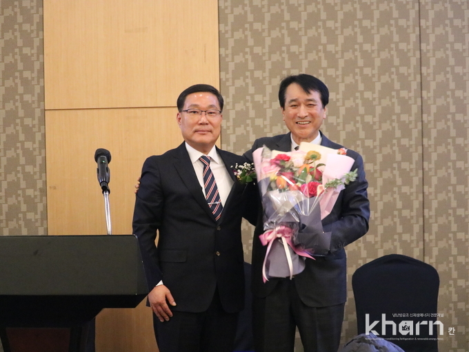 전준혁 차기 회장(좌)과 김영화 회장이 감사패와 꽃다발을 전달한 후 기념촬영하고 있다. 