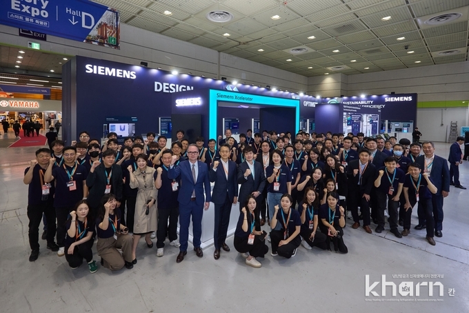 스마트, 공장자동화 산업전 2024에 참가한 지멘스의 임직원들이 부스 앞에서 기념촬영하고 있다.