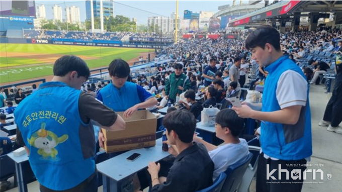 국토관리원의 관계자들이 야구장에서 아동들에게 간식을 나눠주고 있다.