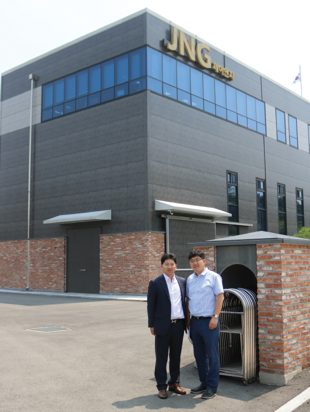 박종우 제이앤지 대표(좌)와 김형일 상무가 신사옥 및 공장을 배경으로 사진촬영하고 있다.